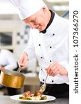 Small photo of Chef in hotel or restaurant kitchen cooking, he is working on the sauce for the food as saucier