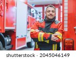 Experienced fire fighter man standing in front of fire truck