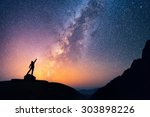 Star-catcher. A person is standing next to the Milky Way galaxy pointing on a bright star.