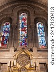 Small photo of Paris, France - July 23, 2023: Inside Sacred Heart of Jesus minor basilica or Sacre Coeur at Montmartre viewing stained glass on wall and tabernacle with golden angels.