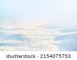 WHITE SNOW IN SUN LIGHT ON LIGHT BLUE FROSTY SKY, BRIGHT WINTER BACKDROP BACKGROUND WITH EMPTY SNOWY FIELD SPACE FOR MONTAGE OR DISPLAY, COLD NATURE LANDSCAPE