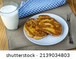 Small photo of French toast - Przenice - slices of bread soaked in beaten eggs and milk and fried, with a glas of yogurt on a wooden table. Eggy bread, Bombay toast, German toast, gypsy toast or poor knightsles