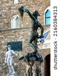 Small photo of Perseus with the Head of Medusa in Loggia Dei Lanzi in front of Florence Palazzo Vecchio and statue of David in Florence, Italy. Architecture and landmark of Florence, postcard of Florence.