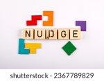 Small photo of NUDGE. Wooden alphabet letters and colorful figures on a white background.