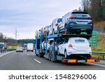 Small photo of Car carrier transporter truck on road. Auto vehicles hauler on driveway. European transport logistics at haulage work transportation. Heavy haul trailer with driver on highway.