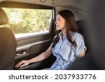 young woman thinking and looking view out of window while sitting in the back seat of car 