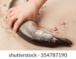 Small photo of Fish day. Raw pike in male hands on a light uniform background