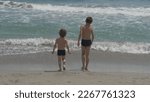 Small photo of Children play with waves, go back and forth, summer and joy time