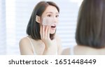 Small photo of Young asian skin care woman upset after use oil blotting paper on her face