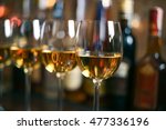 Row of glasses of white wine Chardonnay in a bar or restaurant in the background bottles with alcohol. Selective focus