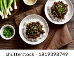 Korean ground beef and rice bowls on wooden background. Top view, flat lay