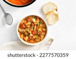 Small photo of Cabbage soup in bowl over white stone background. Top view, flat lay
