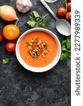 Small photo of Gazpacho soup in bowl over dark stone background with free text space. Cold tomato soup. Top view, flat lay