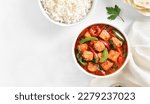 Small photo of Thai style red chicken curry with vegetables in bowl over light background with free text space. Top view, flat lay