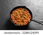 Keema curry in cast iron pan on black stone background. Indian and pakistani style dish. Close up view