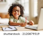 Small photo of Distance education. Smiling african american child schoolboy studying online on laptop at home, sitting at table and communicating with teacher through video call on computer