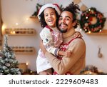 Happy african american family loving father and son hugging embracing while cooking together in kitchen on Christmas, dad and child baking xmas gingerbread cookies during winter holidays