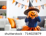 happy laughing child girl in witch costume to halloween