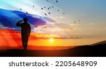 Silhouette of russian soldier in uniforms on background of sunset sky with the Russian flag. Military recruitment concept.