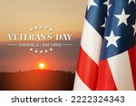 American flags with Text Veterans Day Honoring All Who Served on sunset background. American holiday banner.