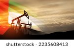 Small photo of The change in oil prices caused by the war. Oil prices are rising because of the global crisis. Oil drilling derricks at desert oilfield with UAE flag. Crude oil production from the ground.