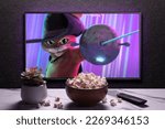 Small photo of TV screen playing Puss in Boots The Last Wish trailer or movie. TV with remote control, popcorn bowl and home plant. Moscow, Russia - December 13, 2022.