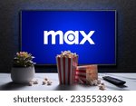 Small photo of Max or HBO Max logo on TV with popcorn boxes, reomote control and home plant on the table. HBO Max is an American subscription video on-demand streaming service. Astana, Kazakhstan - July 21, 2023.