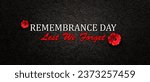 Small photo of Remembrance Day Lest We Forget inscription with Poppy flower on black textured background. Decorative flower for Remembrance Day. Memorial Day. Veterans day.