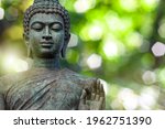 Buddha face, The Buddha statue is made of gold, bronze. On natural bokeh background