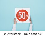 Woman completing a puzzle with a 50% off discount icon, she is putting the missing piece, shopping and discounts concept