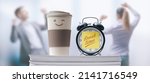 Small photo of Business people taking a break in the office, alarm clock with sticky note in the foreground