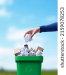 Small photo of Woman putting paper in the waste bin, separate waste collection and recycling concept