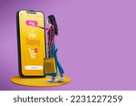 Small photo of Happy woman doing online shopping using a big smartphone, she is holding shopping bags and touching the buy button on the screen