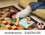 Drunk Young Handsome Man Resting on Couch in the Living Room with Head on the Floor.
