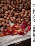 Small photo of Close up view of nutmeg and mace being dried on the ground of the nutmeg forest in Banda Besar or Lonthoir island, Banda Islands, Indonesia, blur background, selective focus