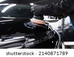Small photo of Man worker of car detailing studio removing scratches on car varnish