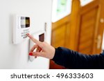 Young woman entering security code on home security alarm system keypad