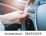 Closeup photo of woman pressing green phone control button on car steering wheel