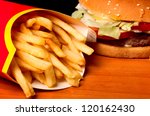fast food set big hamburger and french fries on black background.