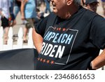 Small photo of Des Moines, Iowa, USA - August 12, 2023: A man wearing an Impeach Biden t-shirt at the Iowa state fair in Des Moines, Iowa, United States.