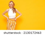 Small photo of Portrait of young beautiful smiling blond female in trendy summer clothes. carefree woman posing near yellow wall in studio. Positive model having fun indoors. Cheerful and happy