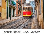 Famous vintage yellow tram 28 in the narrow streets of Alfama district in Lisbon, Portugal - symbol of Lisbon, famous popular travel destination and tourist attraction