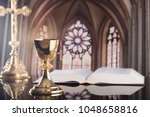 Catholic concept background. Golden chalices on the altar, bible, cross.