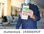 unidentified manwearing a face mask and holding a passport and a Green pass certificate of vaccination.The European Union will propose issuing a certificate called a Digital Green Pass
