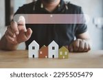 Small photo of Hand of man touching magnifying glass icon search for find information data about home on top of a model wood house. Search advertising for rent or buy a home. Search Engine Optimization
