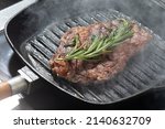 Small photo of Premium dry-aged rib-eye steak grilling on a kamado grill. Dry-aged raw meat steak grilling and smoking on direct fire. Perfect grill marks, and golden crust on the grilled meat. Grilling rib eye