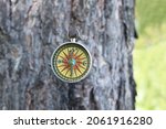 Small photo of round compass on natural background as symbol of tourism with compass, travel with compass and outdoor activities with compass
