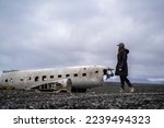 young woman at damaged dc 3 plane in iceland black beach