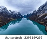 symmetrical erial view over blue mountain lake in norwegian mountains with reflections