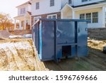 Blu dumpster, recycle waste and garbage bins near new construction of appartment houses building